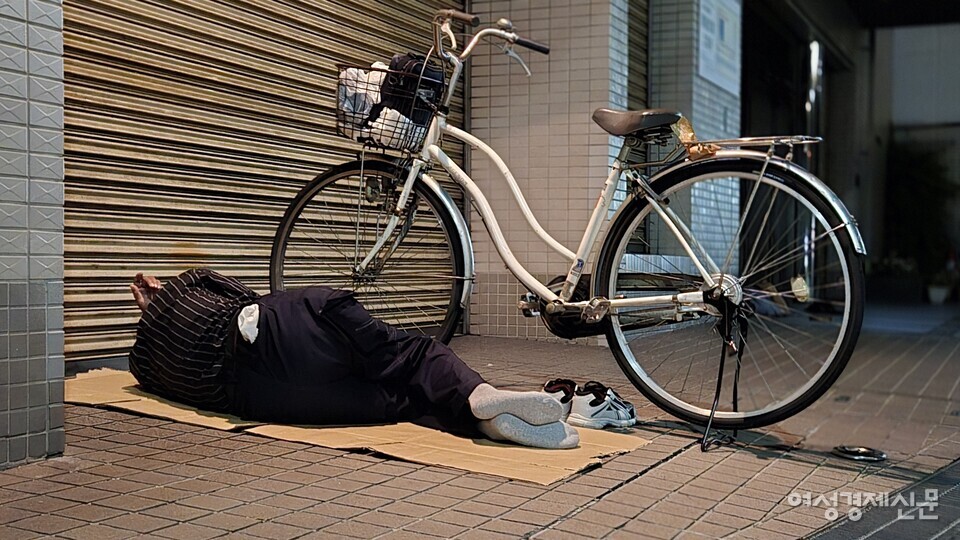 13일 오사카 아이린지구에서 한 노숙인이 길거리에서 잠을 청하고 있다. /오사카=김현우 기자
