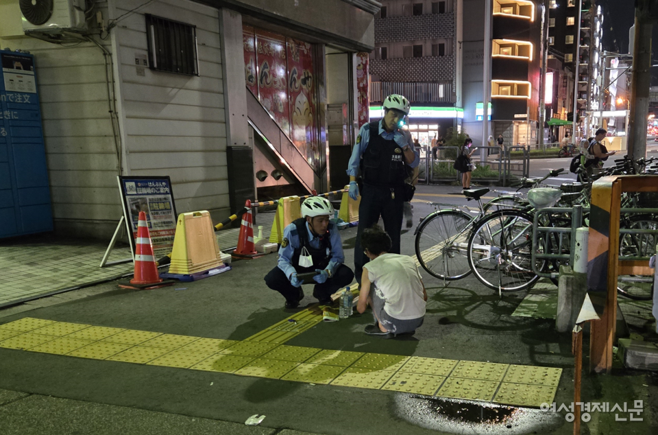 아이린지구 지역 경찰이 노숙인을 이동시키고 있는 모습. 노숙인이 앉아있는 거리는 역과 가까워 외국인이 많은 곳이다. /오사카=김현우 기자