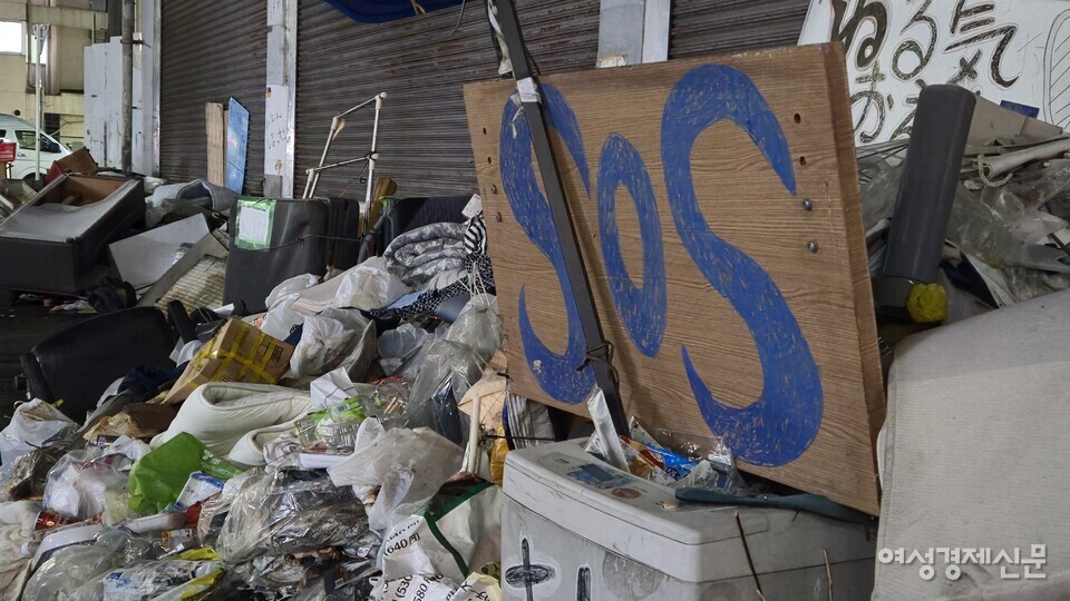 아이린지구 거리에 놓인 쓰레기더미 사이로 'SOS'라고 적힌 박스 조각이 눈에 띈다. /오사카=김현우 기자