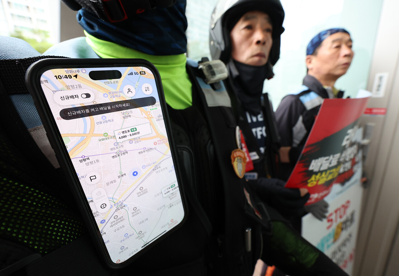 배달플랫폼노동조합이 지난 8월 27일 오전 서울 영등포구 배달의 민족 B마트 앞에서 연 'B마트 멈춤의 날 선포 기자회견'에서 참가자들이 배달 관련 앱을 켜둔 채로 손팻말을 들고 있다. /연합뉴스