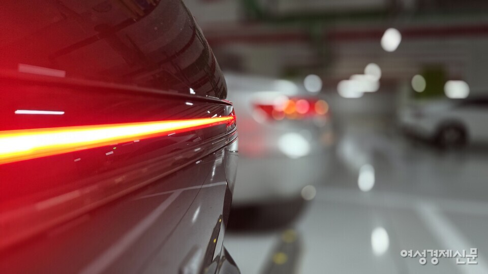 나란히 주차되어 있는 2024년식 그랜저 하이브리드와 2009년식 그랜저TG. 24년식 그랜저만의 일자 후면 램프가 인상적이다. /김현우 기자