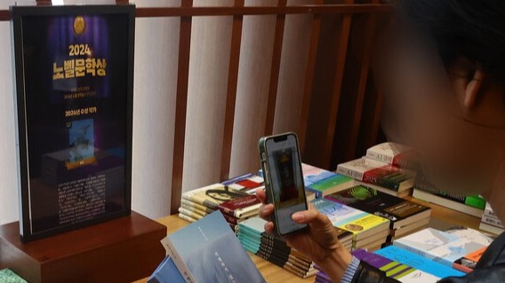 서울 종로구 교보문고를 찾은 시민들이 10일 노벨문학상 수상자로 선정된 소설가 한강의 책을 읽어보고 있다. /연합뉴스