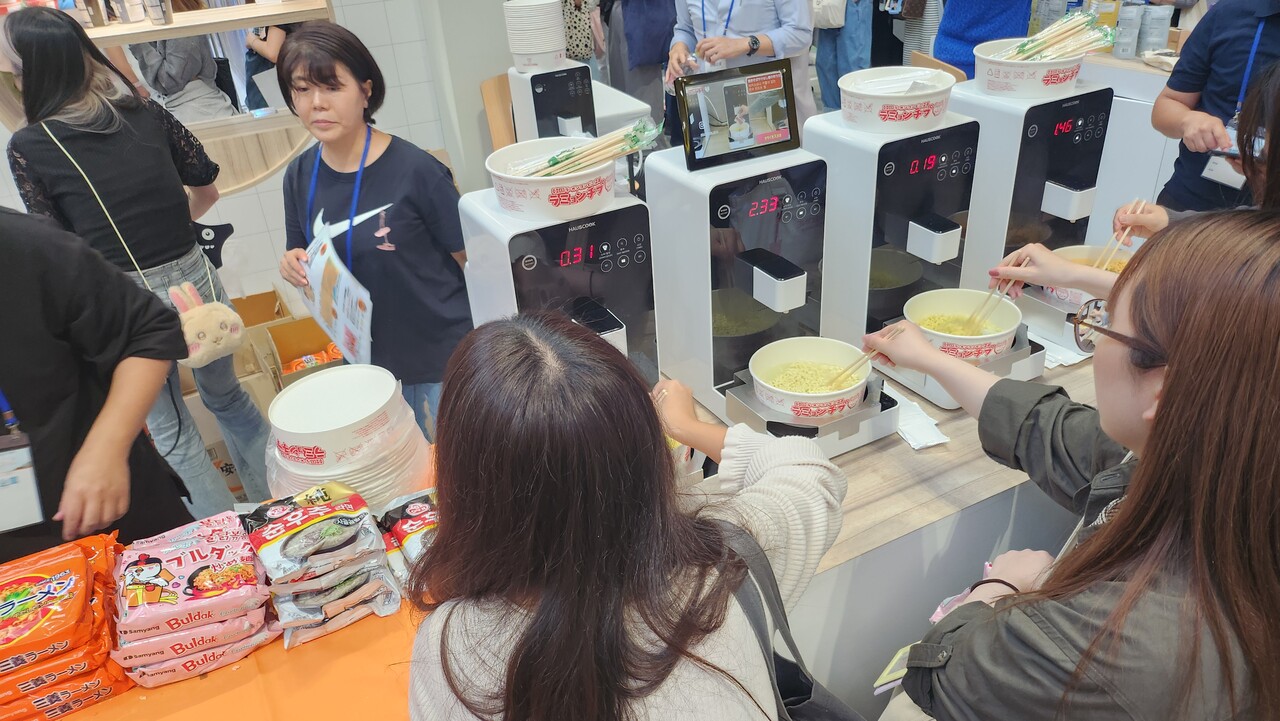 지난 13일 도쿄 사이타마 슈퍼아레나에서 열린 ‘2024 도쿄 한류박람회’에서 즉석 라면 조리기로 한국 라면을 조리하는 현지 관람객들 /류빈 기자