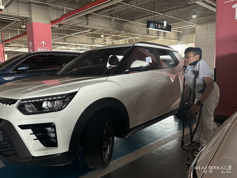 평소 목발을 사용하는 운전자 이성수 씨(남·62)가 용산 아이파크몰 장애인 전용 주차구역에 주차 후 차에서 내리고 있다. /여성경제신문