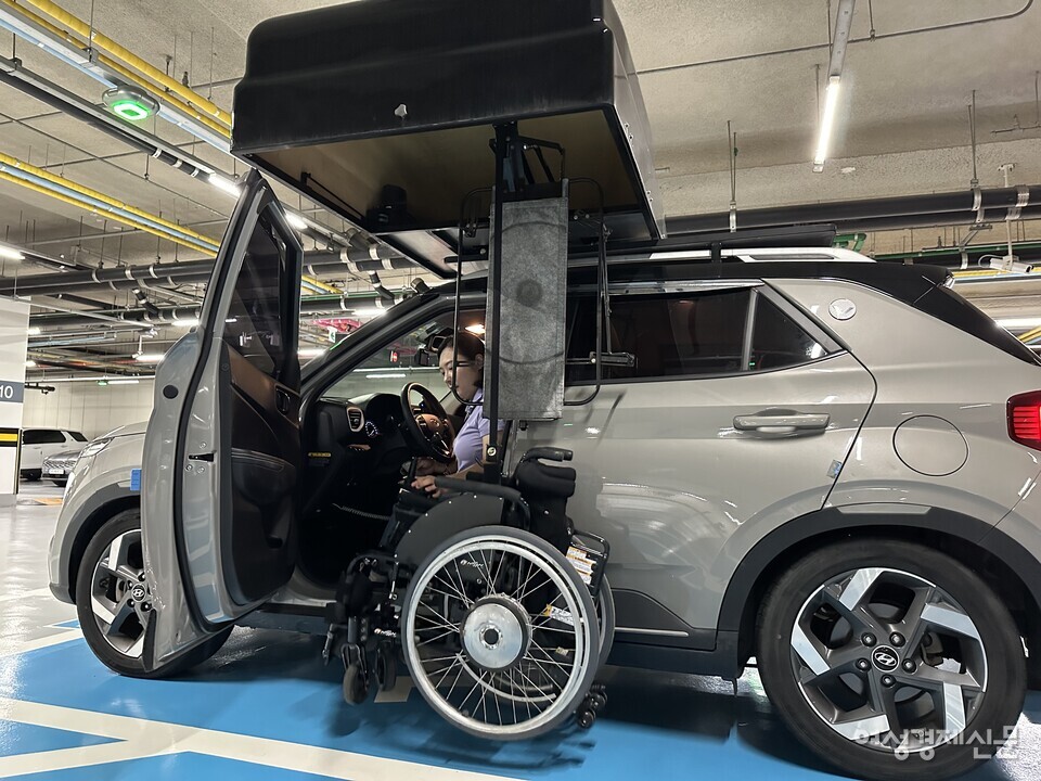 장애인 운전자 홍서윤 씨가 차량을 주차하고 휠체어를 꺼내는 모습. 하반신 장애인 운전자는 리프트를 활용해 휠체어를 차량 루프에 보관한다. 따라서 리프트를 통한 휠체어 이용을 위한 충분한 주차 공간 확보가 필수다. /여성경제신문