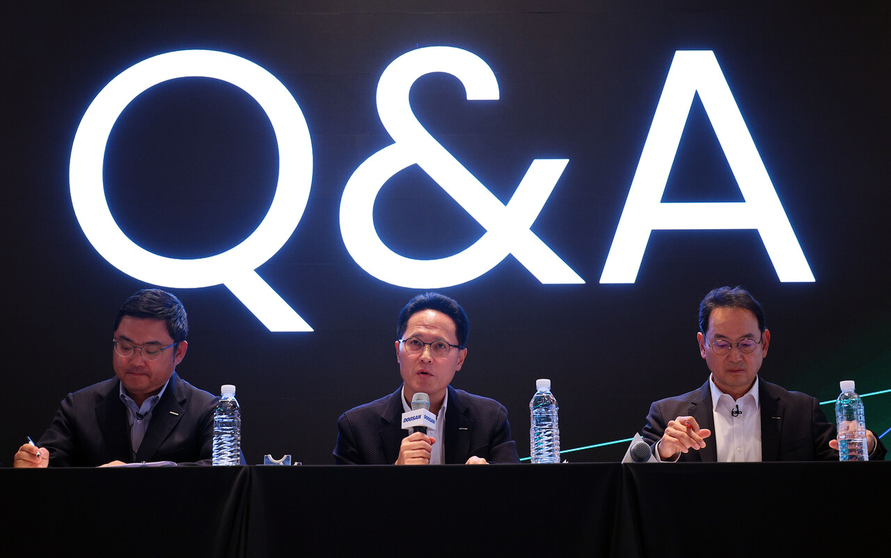 박상현 두산에너빌리티 대표가 지난 21일 서울 중구 플라자호텔에서 열린 두산에너빌리티-두산로보틱스 분할합병 건 기자간담회에서 취재진 질문에 답하고 있다. 왼쪽부터 류정훈 두산로보틱스 대표, 박 대표, 스캇 박 두산밥캣 부회장 /연합뉴스