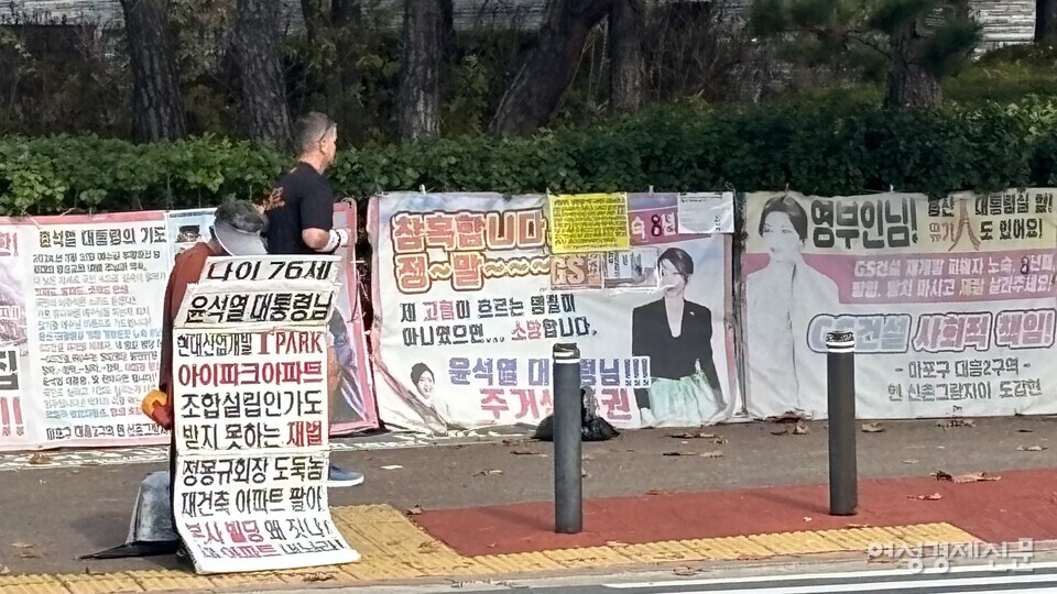 한 시민이 피켓을 목에 걸고 확성기를 통해 현대산업개발 문제를 호소하고 있다. /김성하 기자