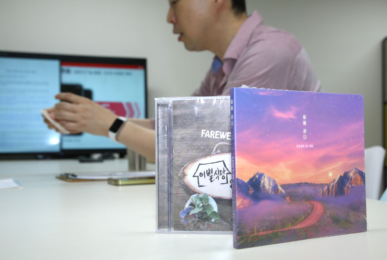 견두현 케이저 대표가 여성경제신문을 만나 직퍼 플랫폼의 개념을 설명하는 가운데 케이저가 자체적으로 발매한 음원 CD롬이 진열돼 있다. /장세곤 기자