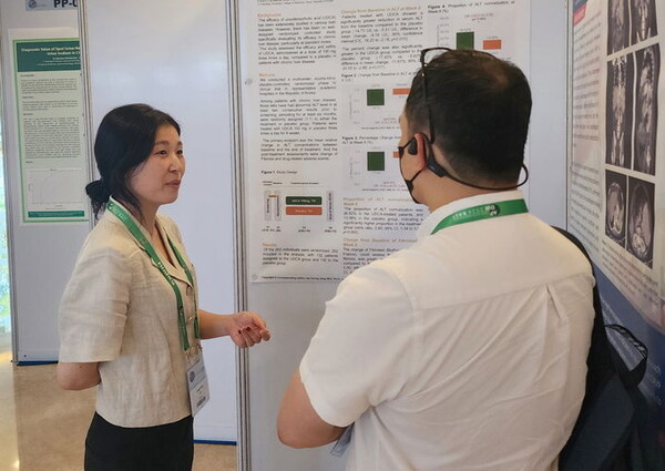 유정민 대웅제약 임상연구팀원(왼쪽)이 해외 의료진에 우루사 임상4상 관련 포스터를 소개하고 있다. /대웅제약