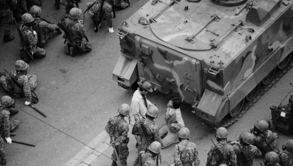 1980년 광주 금남로에서 시민과 학생들이 군사정권 퇴진을 요구하며 대형 버스를 앞세우고 시위하는 학생을 계엄군이 연행해 탱크 앞에서 무릎을 꿇리고 있다. /연합뉴스
