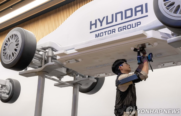 현대자동차·기아는 지난 27일 경기 고양시 '현대 모터스튜디오 고양'에서 열린 '웨어러블 로봇 테크데이'에서 상완 근력을 보조하는 착용형 로봇 '엑스블 숄더'를 최초로 공개하고 사업화 계획을 발표했다고 28일 밝혔다. 로보틱스랩 연구원이 '엑스블 숄더'를 착용하고 모형 차량 하부 부품을 체결하는 시연을 진행했다. /연합뉴스