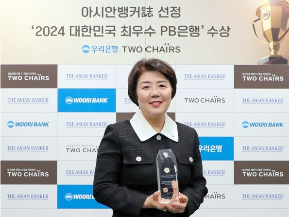 우리은행 송현주 자산관리그룹장이 아시안뱅커가 수여한 '글로벌 웰스 앤드 소사이어티 어워즈' 수상 트로피를 들고 기념촬영을 하고 있다. /우리은행