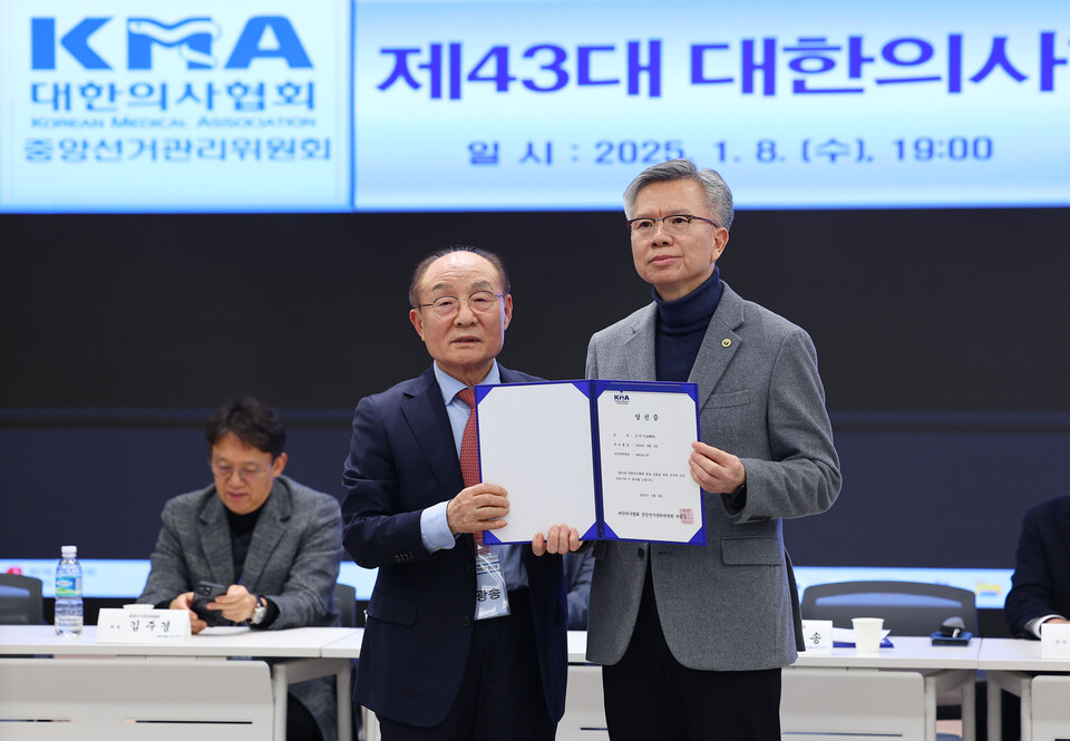 제43대 대한의사협회장에 당선된 김택우 전국광역시도의사협의회장(오른쪽)이 8일 오후 서울 용산구 대한의사협회에서 당선증을 들어 보이고 있다. /연합뉴스