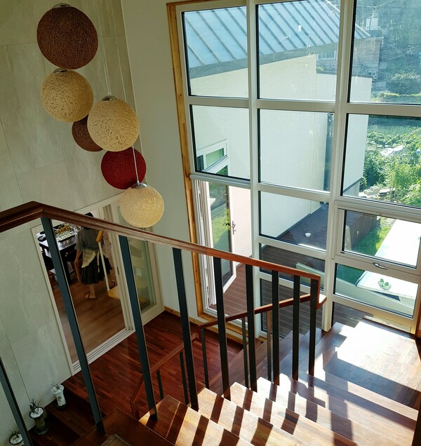 심한재 계단 홀, 거실채와 침실채를 나누는 공간이지만 이 집의 전체 공간을 하나로 이어주는 역할을 한다. 1층 부부 영역과 2층 아이들과 손님 영역은 층으로 나뉘지만 거실채가 가운데 층에 있어 프라이버시와 커뮤니케이션이 함께 유지되고 이루어진다.