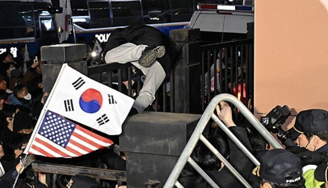 윤 대통령 지지자들이 서부지법 담을 넘는 모습이다. 당시 일부 윤 대통령 지지자들이 시민들에게 "중국인이냐"라고 추궁하고 현장 경찰들을 향해 "중국 공안이니 걷어차라"라고 한 바 있다. /연합뉴스