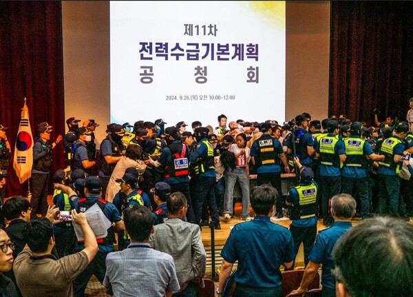 신규 원전 4기 건설과 무탄소 에너지 확대 등을 골자로 한 '제11차 전력수급기본계획' 공청회에서 환경단체들이 단상을 점거하며 무력시위를 하자 경찰들이 진압하고 있다. /산업통상자원부