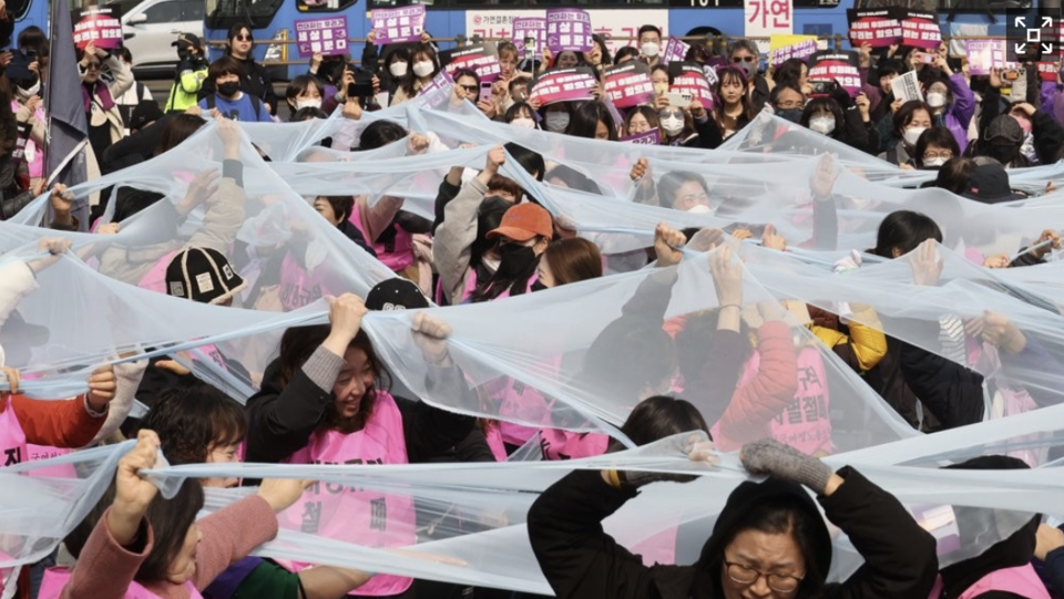 세계여성의날을 나흘 앞둔 지난 2023년 3월 4일 서울 종로구 보신각 앞에서 여성노동연대회의가 주최한 2023 여성노동자대회에서 참가자들이 여성차별의 상징인 유리천장을 깨고 나가자는 의미로 투명한 천을 찢는 퍼포먼스를 하고 있다. /연합뉴스