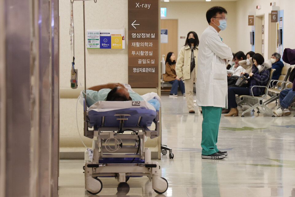 의정갈등이 이달로 1년이 된 지난 3일 서울 시내의 한 대학병원에서 한 의료진 뒤로 환자가 침상에 누워있다. /연합뉴스