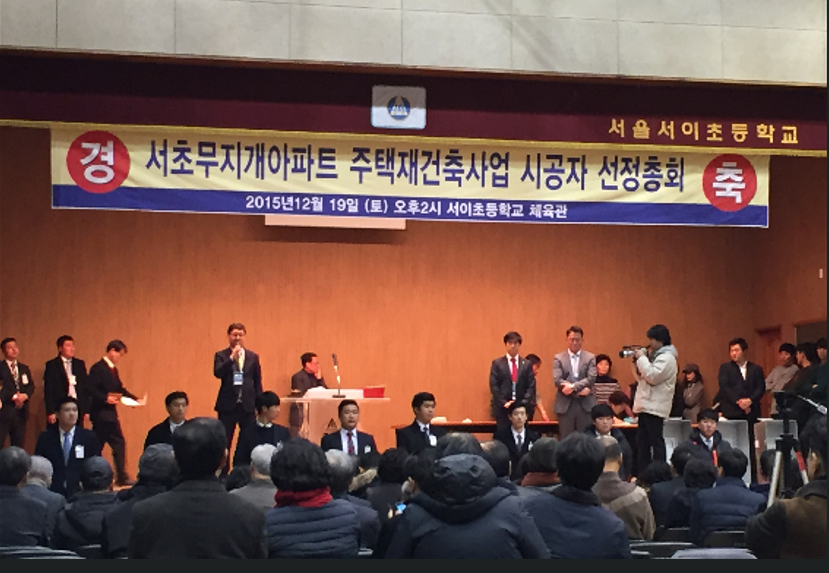 2015년 12월 당시 서울 서이초등학교 강당에서 열린 서초무지개아파트 재건축 시공사선정총회에서 개표가 끝난 후 GS건설 관계자가 감사인사를 하고 있다. /유준상 기자