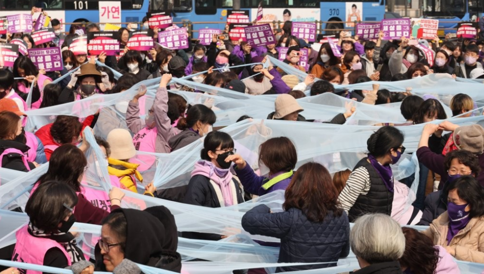 세계여성의날을 나흘 앞둔 2023년 3월 4일 서울 종로구 보신각 앞에서 여성노동연대회의가 주최한 2023 여성노동자대회에서 참가자들이 여성 차별의 상징인 유리천장을 깨고 나가자는 의미로 투명한 천을 찢는 퍼포먼스를 하고 있다. /연합뉴스