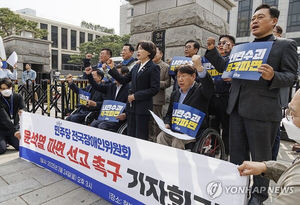 더불어민주당 전국장애인위원회 소속 당원들이 24일 서울 종로구 헌법재판소 정문 앞에서 헌재의 윤석열 대통령 탄핵 심판 선고를 촉구하는 기자회견 도중 구호를 외치고 있다. /연합뉴스