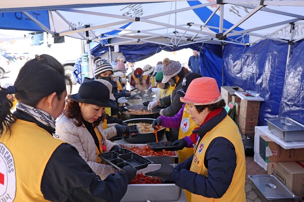 적십자 관계자들이 30일 경북 영덕군 영덕국민체육센터 앞에서 산불 이재민을 위한 점심 식사를 담고 있다. /연합뉴스