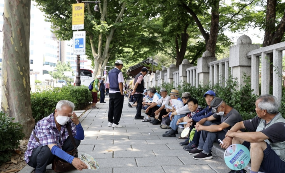 서울 종로구 탑골공원에서 어르신들이 햇볕을 피해 무료급식을 기다리고 있다. /연합뉴스