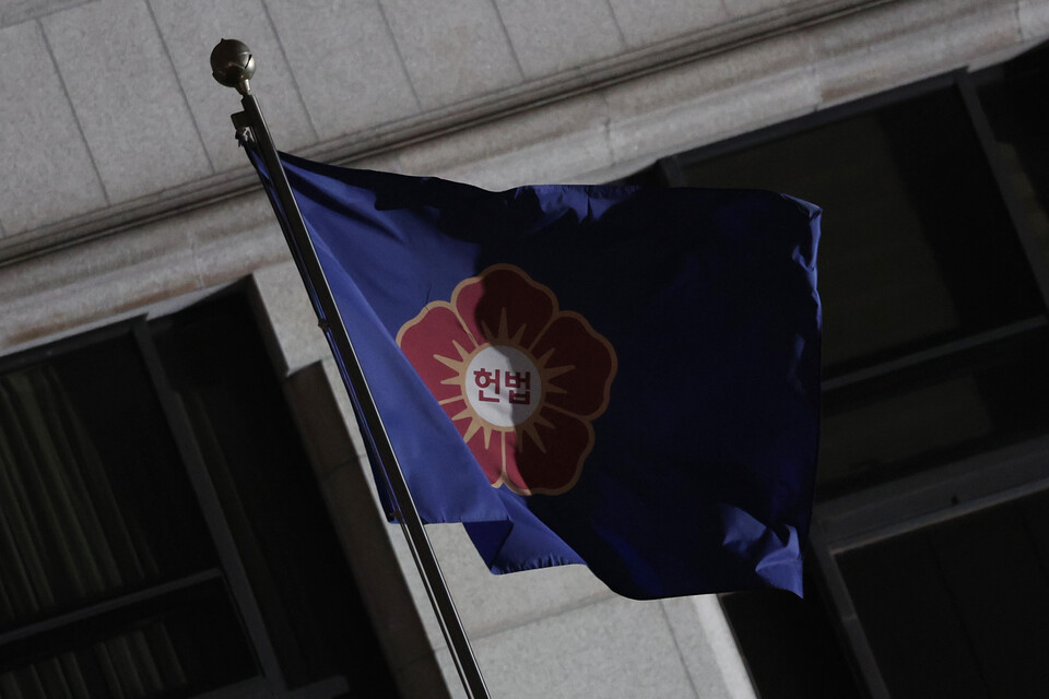 윤석열 대통령 탄핵 심판 선고일을 이틀 앞두었던 지난 2일 서울 종로구 헌법재판소에서 휘날리는 깃발 위로 그림자가 드리워져 있다. /연합뉴스