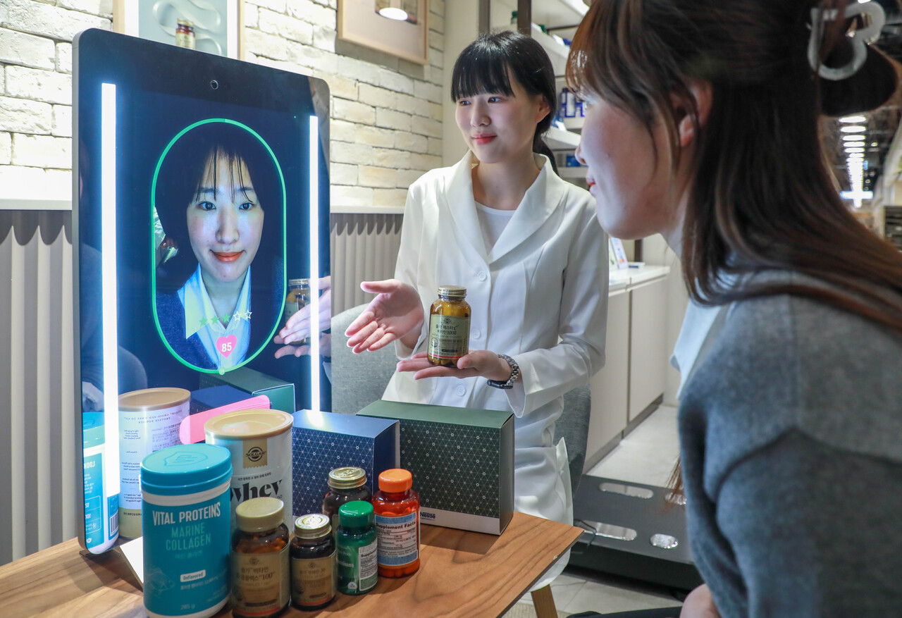 고객이 현대백화점 목동점 네슬레 헬스사이언스 매장에서 AI 기반 헬스케어 전문 기기 ‘아누라 매직미러’를 체험하고 있는 모습 /현대백화점그룹