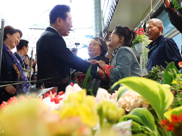 영남 신라벨트 골목골목 경청투어에 나선 더불어민주당 이재명 대선 후보가 지난 10일 경남 함안군 가야전통시장 내 한 꽃가게를 찾아 상인들과 인사를 하고 있다./연합뉴스 