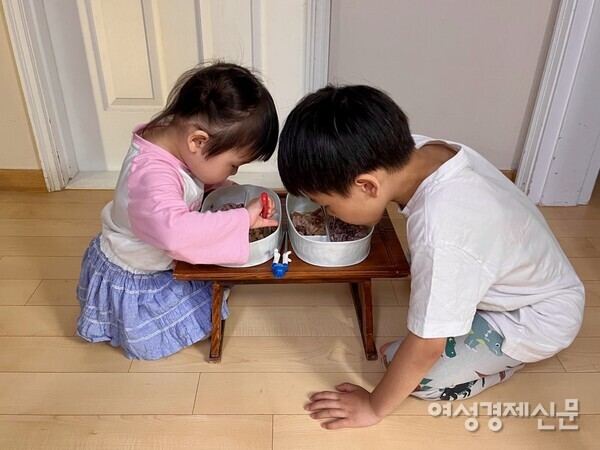 머리를 맞대고 소반에서 밥을 먹는 필자의 두 아이 /프레스 모멘트