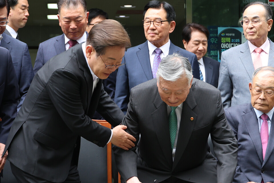 더불어민주당 이재명 대선 후보가 19일 서울 용산구 대한노인회관을 방문, 기념촬영 자리에 앉는 이중근 회장을 부축하고 있다. /연합뉴스