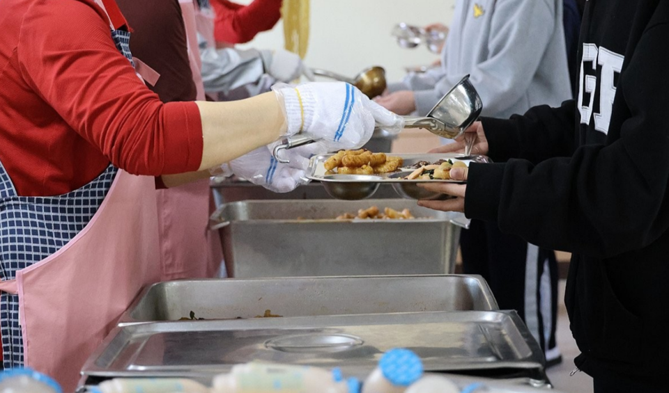 대전 서구 둔산여고가 지난 4월 2일부터 저녁 급식 제공을 중단한 가운데 11일 오후 이 학교 급식실에서 학생들이 점심을 받고 있다. /연합뉴스