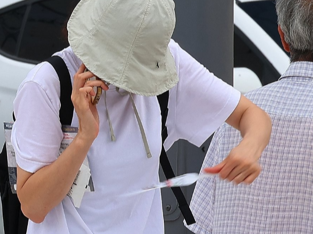 한 시민이 옷에 붙은 러브버그를 털어내고 있다. /연합뉴스