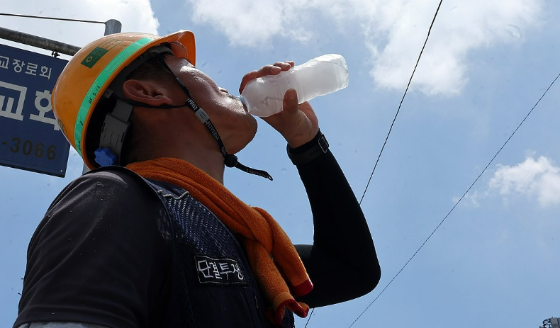 엿새째 폭염 특보가 내려진 지난 2일 광주 서구 금호동 한 공사장 앞에서 한 건설노동자가 더위를 달래기 위해 얼음물을 마시고 있다. /연합뉴스