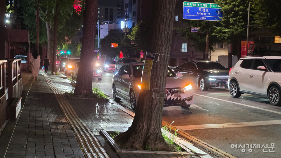 서울 마포구 대흥로 학원가에서 밤마다 학부모 차량이 불법 정차하며 자녀를 기다려 도로 한 차선을 점거, 교통 혼잡이 반복되고 있다. 단속은 실효성이 낮고 주민 불편은 계속되고 있다는 목소리가 나온다. 사진은 학원생의 하원을 기다리며 2차선 2차로에 불법 주정차를 하고 있는 차량 모습. /김현우 기자