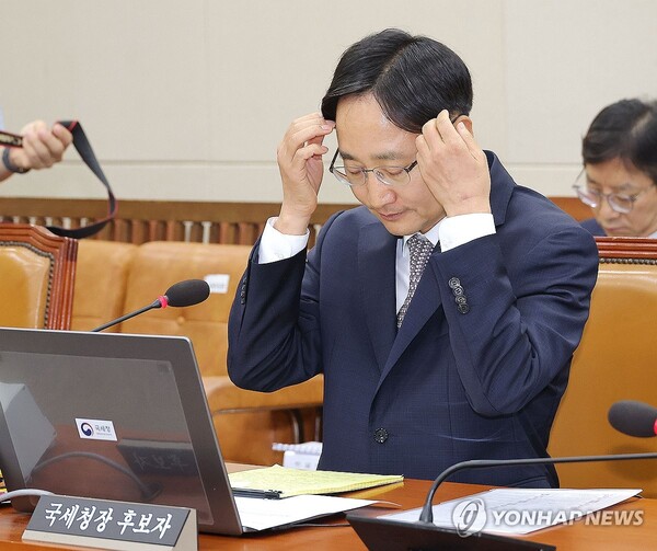 임광현 국세청장 후보자가 15일 서울 여의도 국회 기획재정위원회에서 열린 인사청문회에서 의원 발언을 듣던 중 머리를 넘기고 있다. /연합뉴스