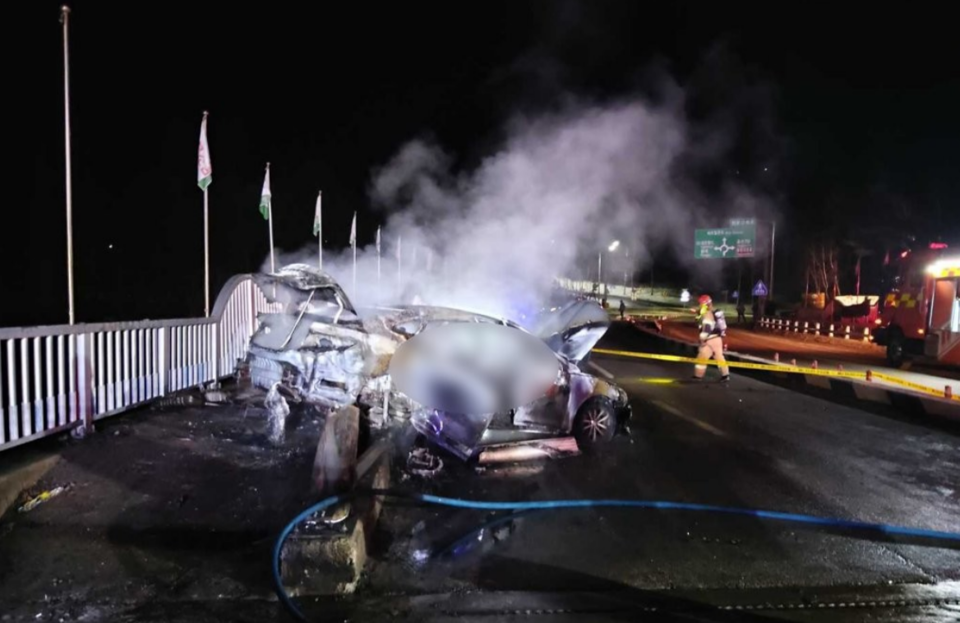 2023년 2월 평창군 대관령면 용산리 회전교차로 인근 교량에서 그랜저 승용차가 가드레일을 들이받은 뒤 불이 나 소방대원이 진화하고 있다. /연합뉴스