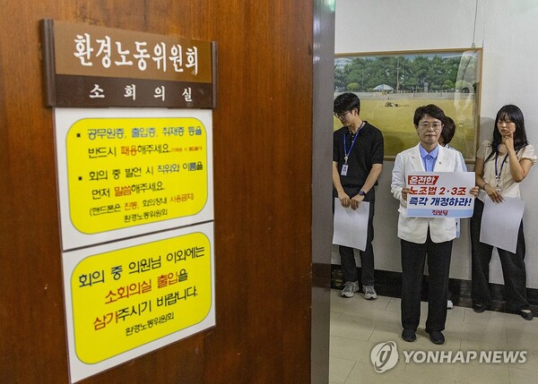 진보당 전종덕 의원이 28일 국회 환경노동위원회 법안소위가 열린 소회의실 앞에서 손팻말을 들고 여야 의원들에게 '온전한 노조법 2ㆍ3조(노란봉투법) 즉각 개정'을 촉구하고 있다. /연합뉴스