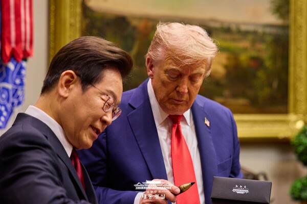 도널드 트럼프 대통령이 지난 25일(현지 시각) 백악관에서 열린 한미 정상회담에서 이재명 대통령이 선물한 서명용 펜을 유심히 들여다보고 있다. /대통령실