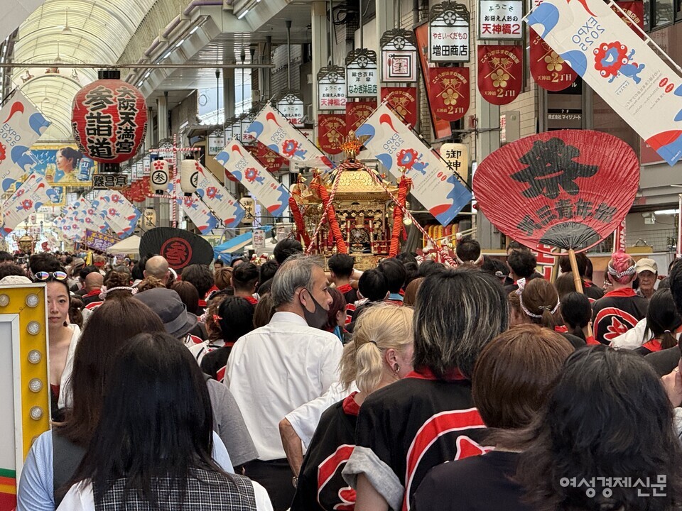 오사카 텐진마쓰리는 학문의 신 스가와라 노 미치자네를 모시며 천년 넘게 이어온 일본 대표 여름 축제다. 원령을 신격화해 재앙을 막는 일본식 신관에서 출발해 육상·수상 행렬과 불꽃놀이로 도시 전체가 참여한다. 어른·아이 모두 역할을 맡으며 공동체 결속을 다지고 현대에는 관광·경제 효과까지 결합된 도시 운영 플랫폼으로 기능한다. /김현우 기자