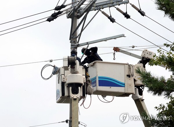 강한 비가 내린 7일 오전, 전북 군산시 문화동의 한 아파트가 단전돼 한국전력공사 관계자가 임시 전력공급을 위해 복구지원을 하고 있다. /연합뉴스