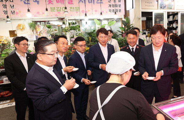 이날 행사에 참석한 이호성 하나은행장(사진 왼쪽에서 두 번째)과 이찬진 금융감독원장(사진 맨 오른쪽)이 내외빈들과 함께 전통시장에서 직접 구입한 명절 음식을 시식하고 있다. /하나은행