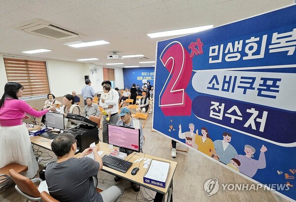 민생회복 소비쿠폰 2차 신청 첫날인 지난달 22일 광주 북구 용봉동 행정복지센터에서 직원들이 주민들에게 소비쿠폰을 지급하고 있다. /연합뉴스