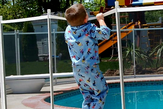 서양의 어느 아이가 울타리 넘어 수영장으로의 진입을 시도하고 있다. /여성경제신문DB