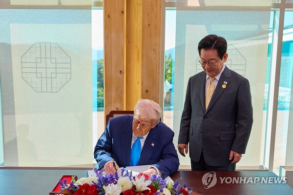  이재명 대통령이 29일 한미 정상회담이 열리는 경북 경주박물관에서 도널드 트럼프 미국 대통령의 방명록 작성 모습을 보고 있다. /연합뉴스