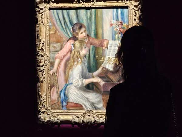   르누아르의 ‘피아노를 치는 두 소녀’(1892). 그림 속 소녀에게 시선을 고정한 듯한 관람객의 모습이 인상적이다. /사진=한형철 초빙기자
