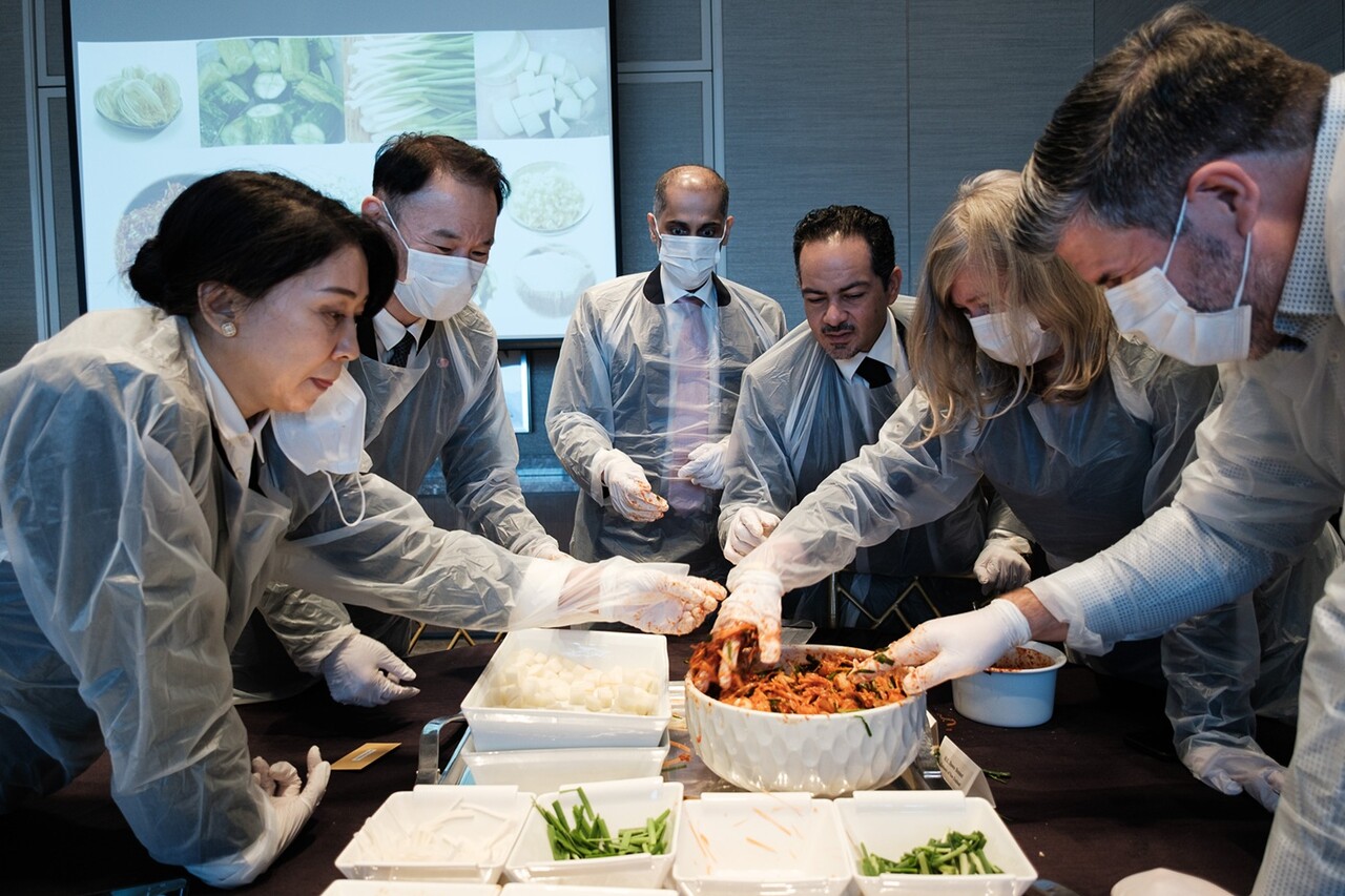 지난 21일 열린 롯데호텔앤리조트의 ‘김치의 날 외교 오찬 행사’에서 각국 대사들이 김장 체험을 하고 있다. /롯데호텔앤리조트
